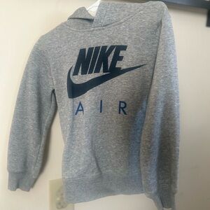 Nike air gray sweater fits four year old and the wording is a navy color